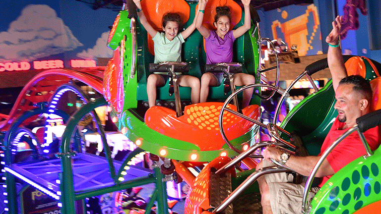 Family Riding the Scream'n Centipede Roller Coaster in Tom Foolerys Adventure Park