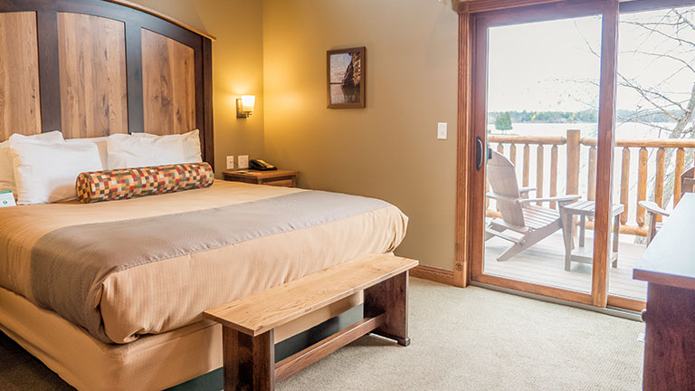 Cottage room with a king size bed and a glass sliding door showing the lake