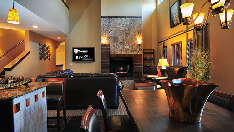 Nyumba Loft living room with a leather couch and chairs surrounding a fireplace